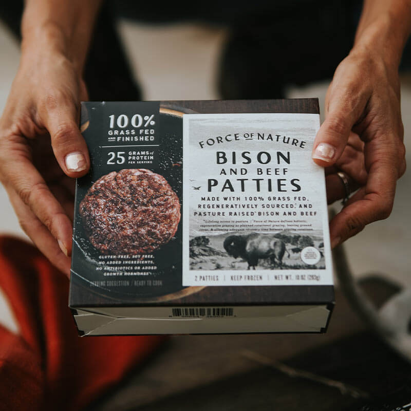 A person holding a Bison & Beef Patties box.