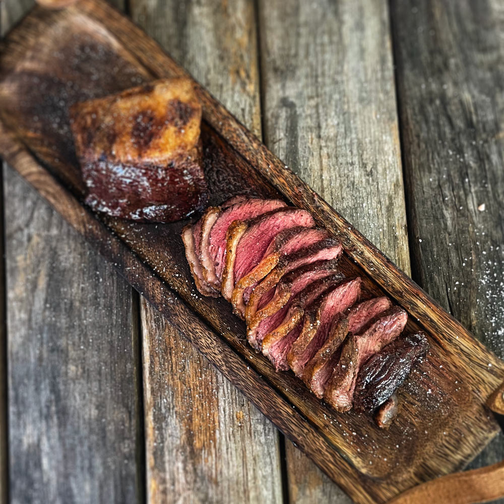 Cooked Picanha steak on a cutting board.