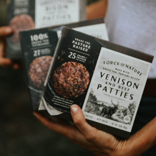 A person holding boxes of Venison patties.
