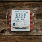 Packaged Beef Hot Dogs on a wooden table.