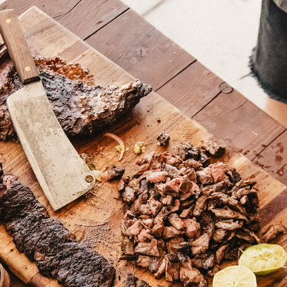 Cooked skirt steak sliced on a wooden cutting board.