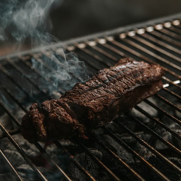 Steak being cooked on a grill.