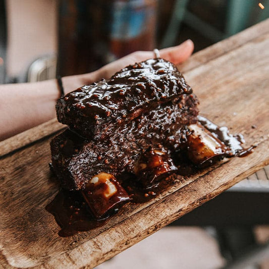 Cooked Bison Short Ribs on a cutting board.