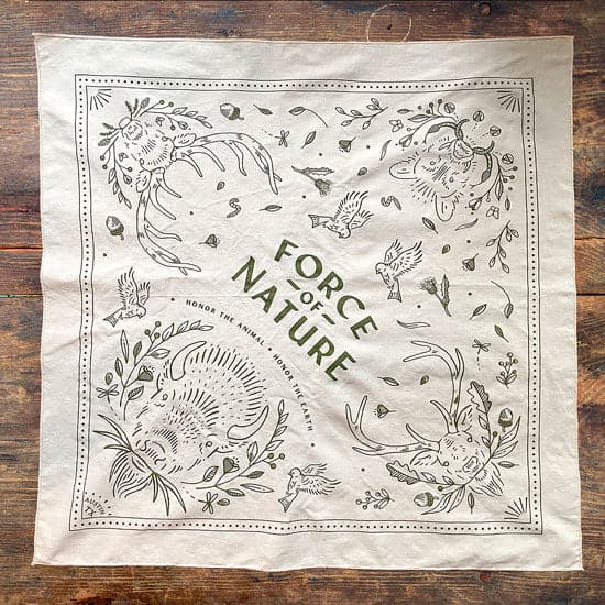 A white Force of Nature bandana on a wooden table.