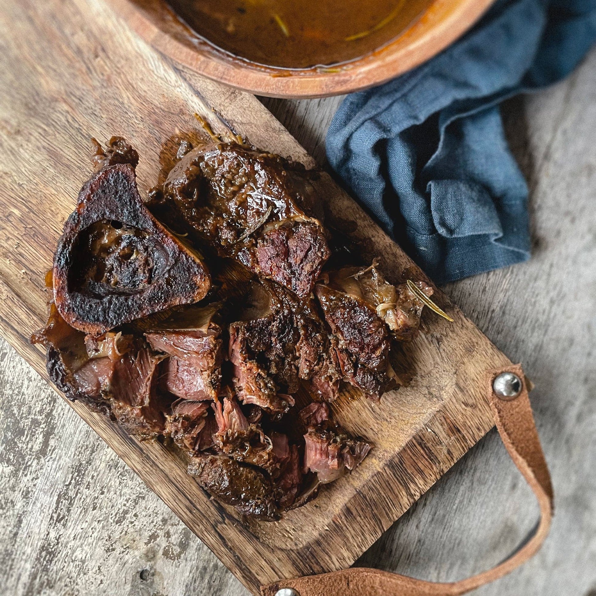 Bison Osso Buco cooked on a cutting board.